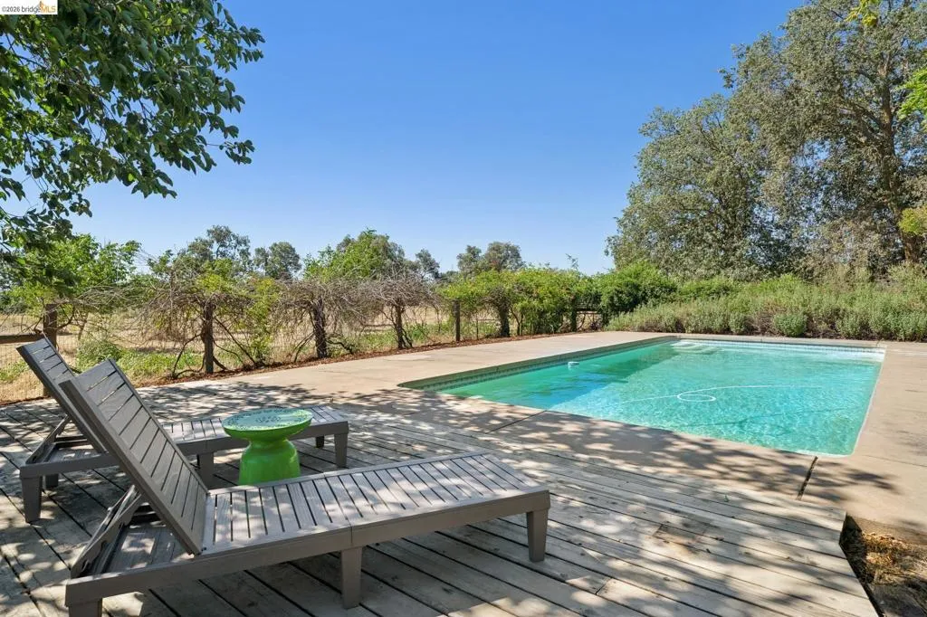 Rectangular swimming pool with a surrounding concrete and wood deck