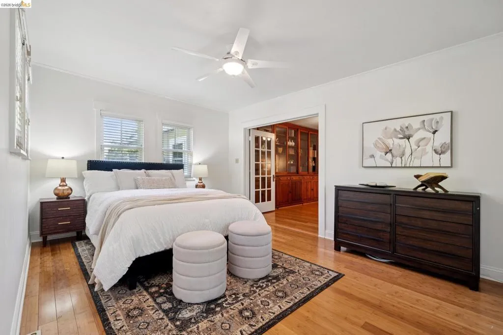 Hardwood flooring throughout, with white walls and ceiling fan