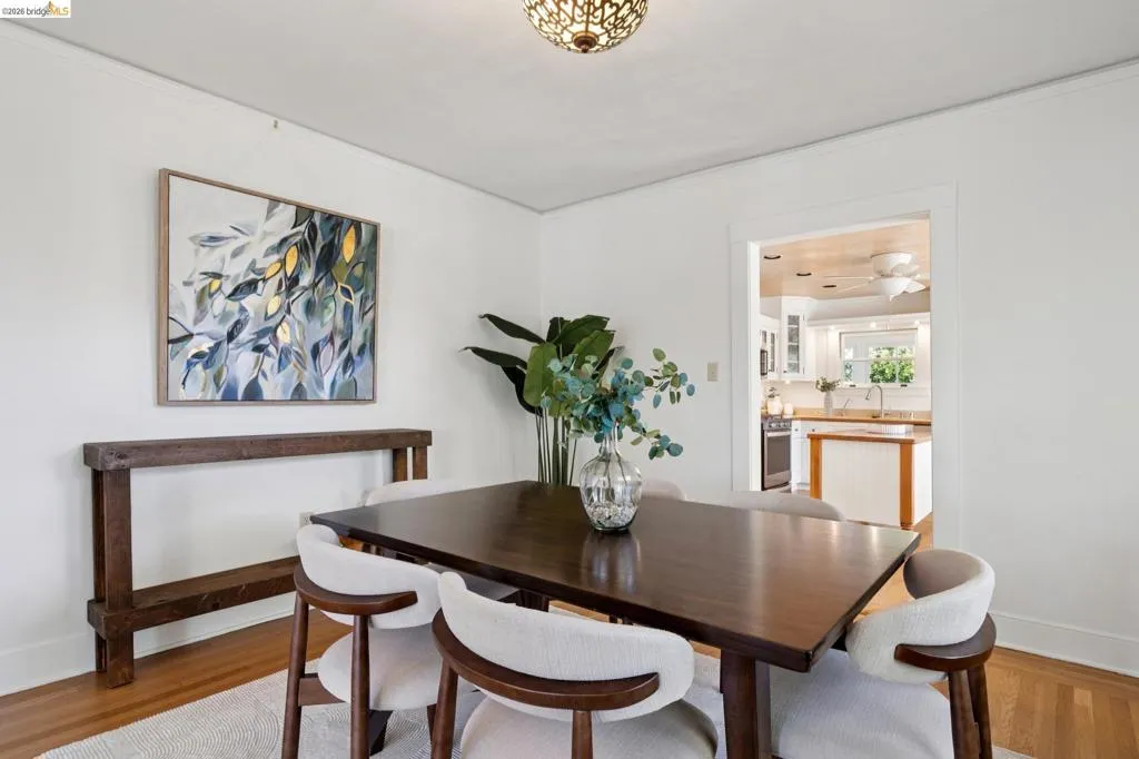 Dining area featuring wood-finish flooring, white walls, and a decorative ceiling light fixture