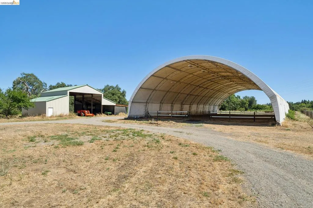 Expansive covered arena with a gravel entry path