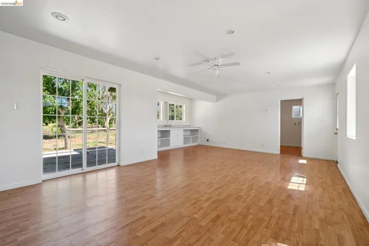 Open-concept interior featuring wood-finish flooring, white walls, and recessed lighting