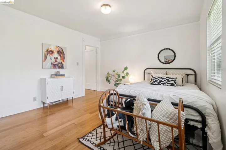 Bright room featuring wood-finish flooring, white walls, and crown molding