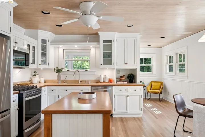 Kitchen featuring white cabinetry, light wood-finish countertops, stainless steel appliances, and a wood plank ceiling