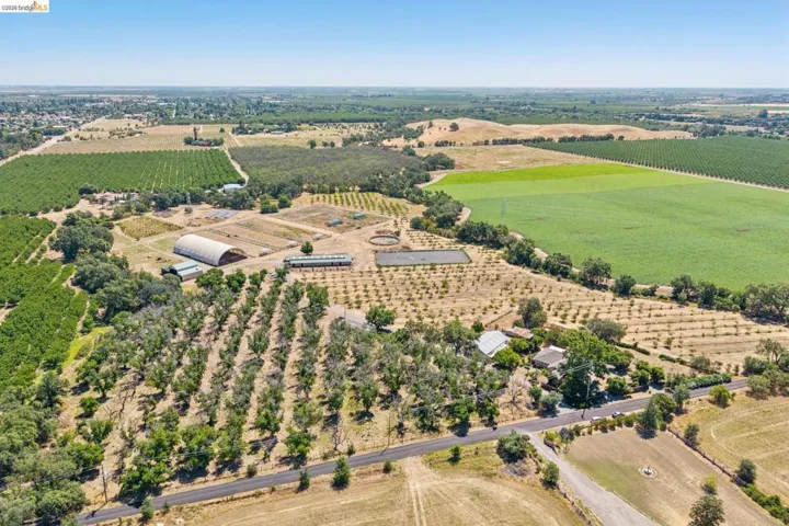 Expansive agricultural property featuring cultivated fields and structured orchards