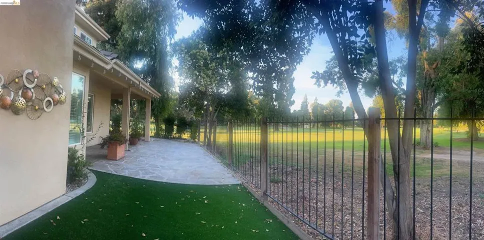 Expansive exterior patio featuring flagstone paving and an artificial turf area