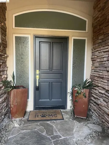 Welcome home! Arched transom window and frosted sidelights frame a paneled entry door
