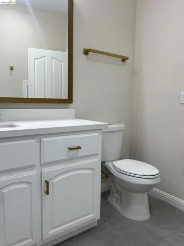 Upstairs Bathroom. Featuring a white vanity with gold-finish hardware, a white quartz countertop, and a framed mirror
