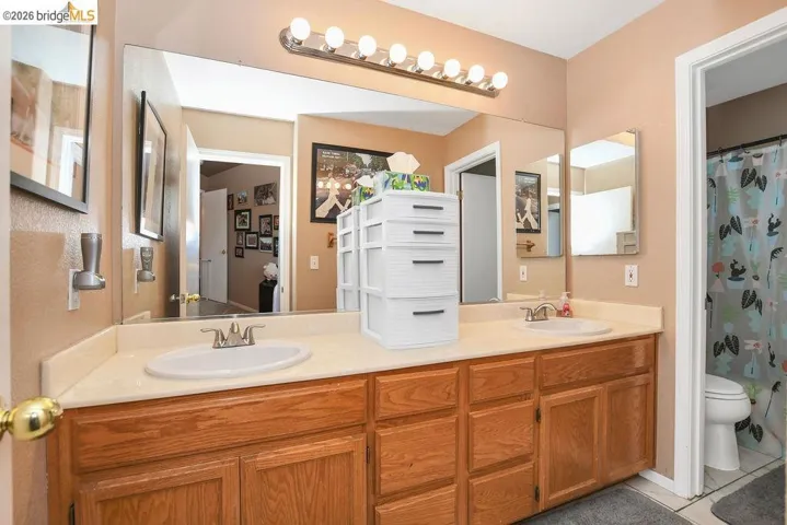 Full bath featuring double vanity and a shower with curtain