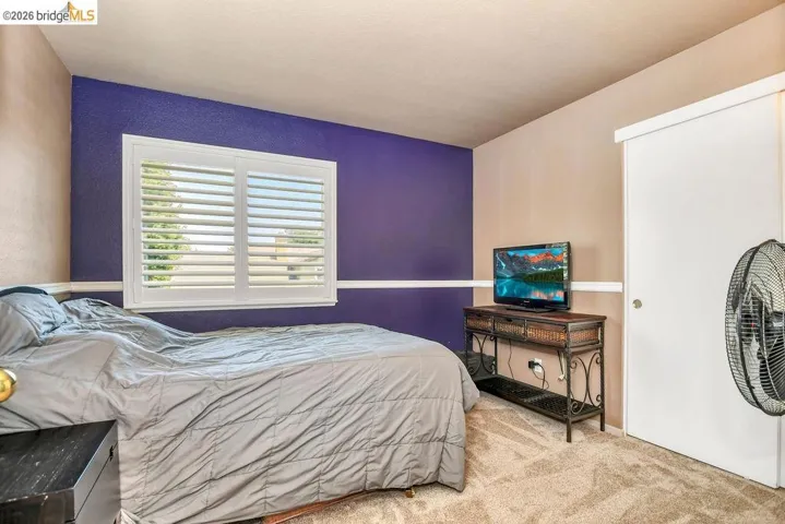 Carpeted bedroom with a textured wall