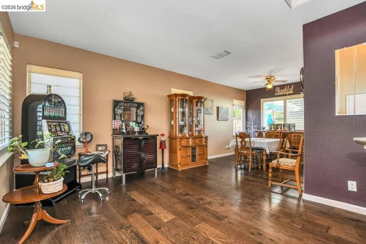 Sitting room with dark wood-style floors and ceiling fan