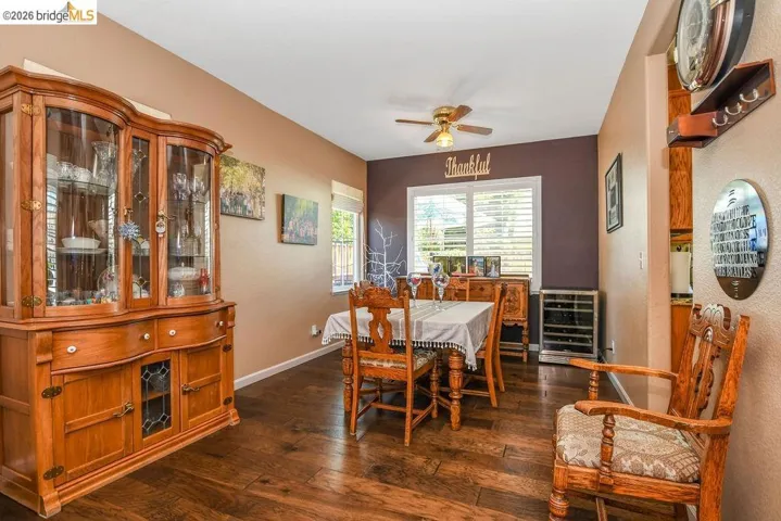 Dining space with dark wood finished floors, beverage cooler, and ceiling fan