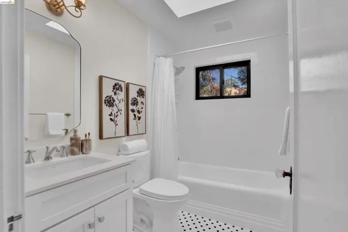 Bathroom featuring a white vanity with an undermount sink, chrome faucet, and integrated countertop