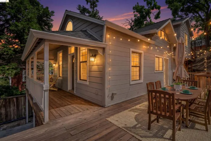 Exterior featuring a spacious wood deck, board-and-batten siding, multiple windows, and a covered porch