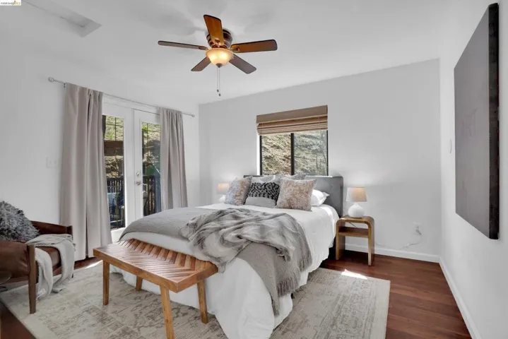 Bedroom featuring rich wood-finish flooring and crisp white walls
