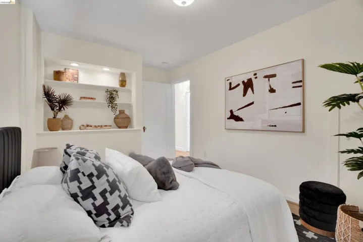 Built-in shelving with recessed lighting, light wood-finish flooring, and a ceiling-mounted light fixture