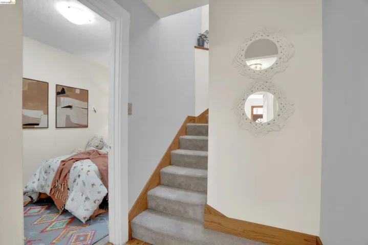 Carpeted staircase with wood-finish railing and trim