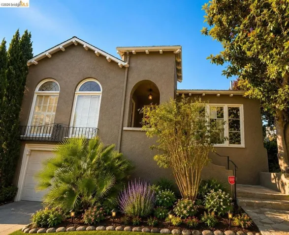 Stucco exterior with arched windows, wrought iron balcony, and a prominent entry archway