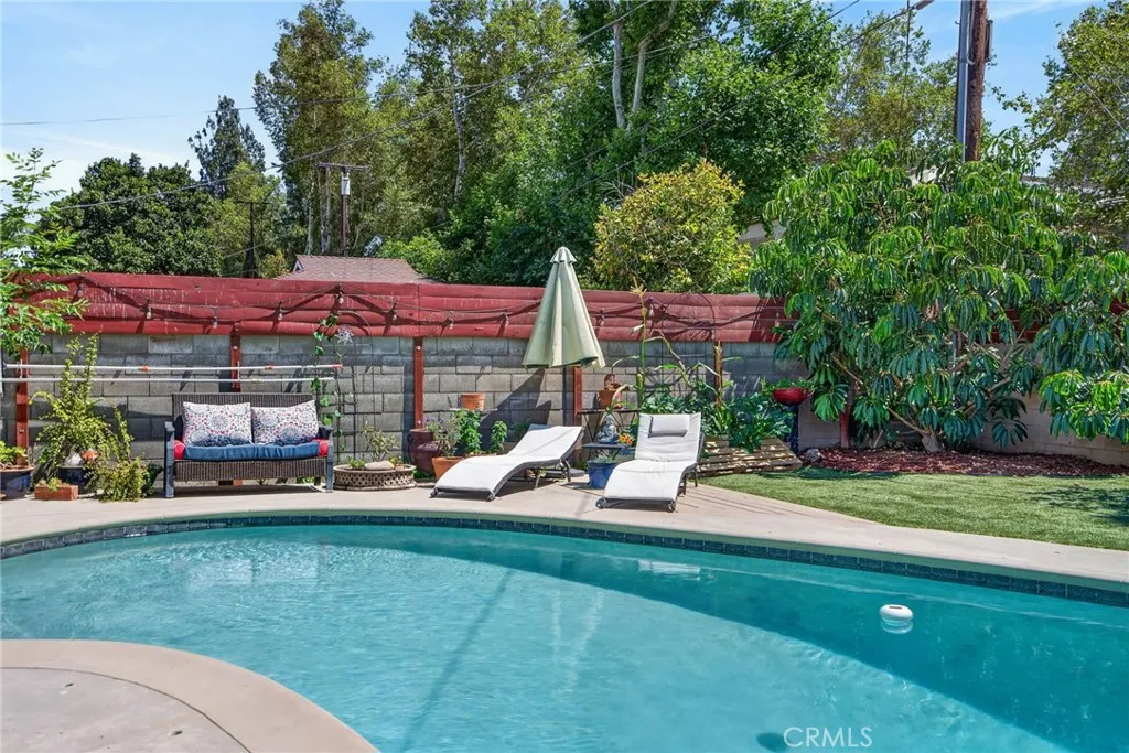 Serene backyard with fruit trees and garden beds -- and the inviting pool creates the perfect setting for staycations and weekend gatherings!