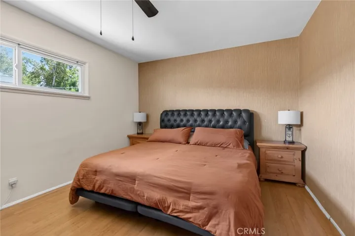 Primary bedroom with ceiling fan and sense of privacy and quiet.