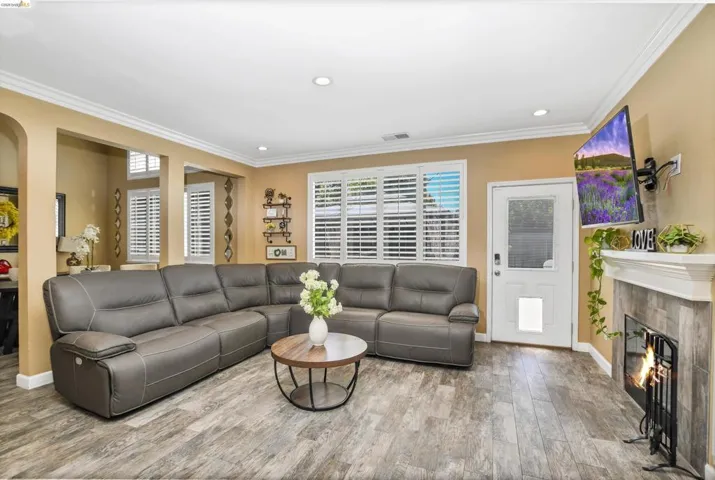 Living area featuring wood-finish flooring, recessed lighting, and crown molding