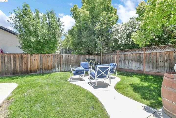 Expansive backyard featuring a manicured lawn, established perimeter fencing, and mature trees providing natural screening