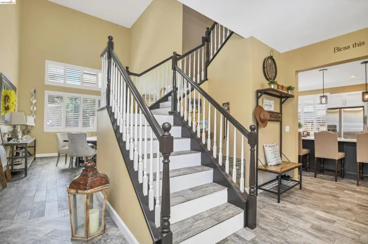 Multi-level staircase featuring dark wood newel posts and handrails with white balusters