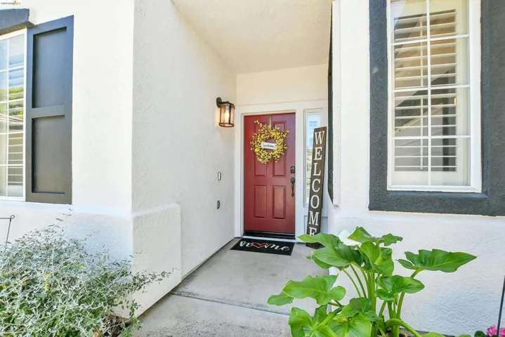 Entryway featuring a red paneled door, sidelight window, and a wall-mounted lantern light fixture