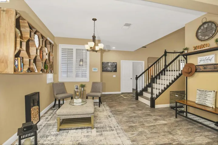 Laminate flooring extends throughout this open living space, featuring a custom wood-finish built-in shelving unit