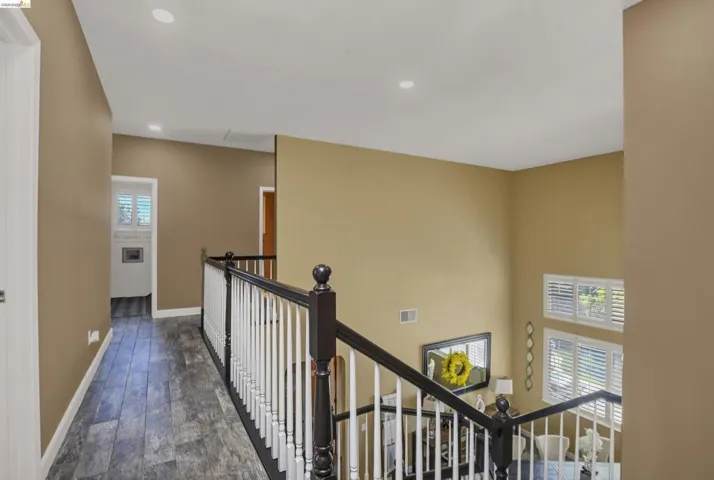 Upper-level hallway featuring wood-finish flooring and recessed lighting