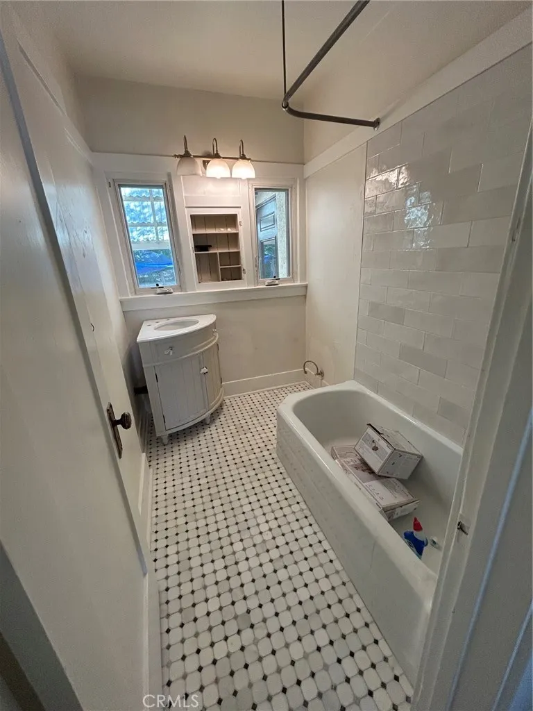Bathroom under construction, newly tiled, corner sink yet to be installed, new toilet