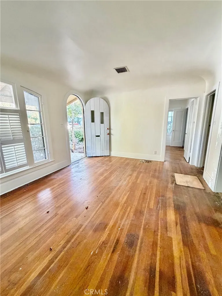 Front room prior to hardwood floors being refinished, wood blinds being removed and front door painted.