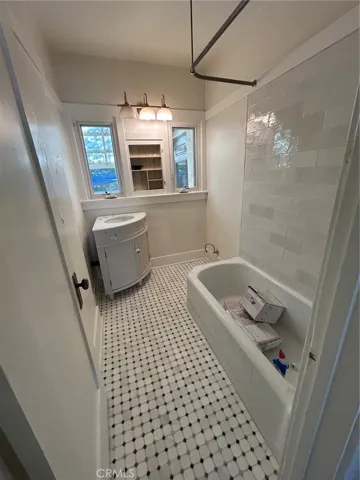 Bathroom under construction, newly tiled, corner sink yet to be installed, new toilet