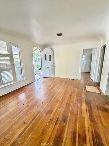 Front room prior to hardwood floors being refinished, wood blinds being removed and front door painted.