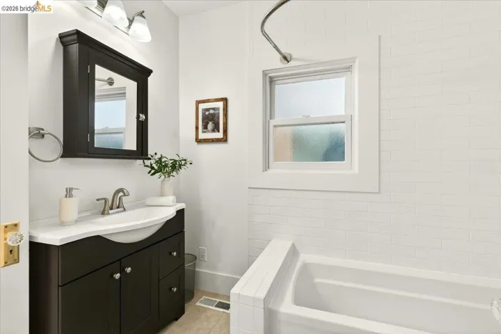 Bathroom vanity featuring a dark wood finish cabinet with a white countertop and integrated sink