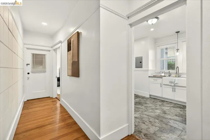 Corridor with wood-finish flooring and white shiplap paneling