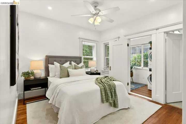 Hardwood flooring and bright white walls with a ceiling fan