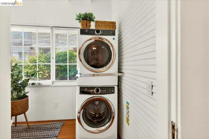 White stacked washer and dryer unit, featuring front-loading doors with bronze accents