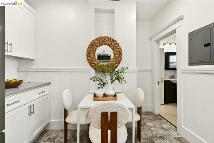 Kitchenette featuring white cabinetry with silver hardware, light gray countertops, and tile flooring