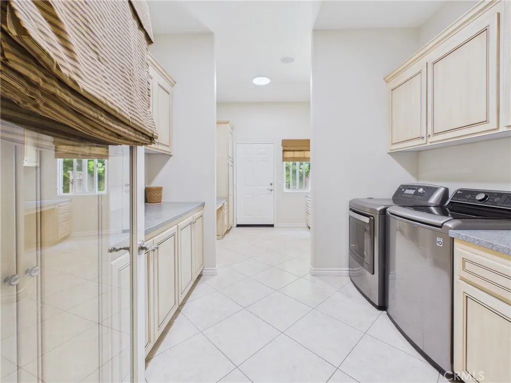Oversized laundry room with exterior door to side yard and RV driveway.