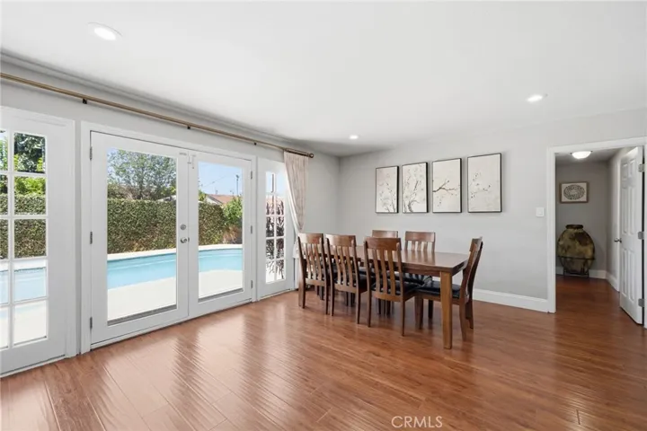 Adjacent dining and living spaces with recessed lighting and french doors that flow seamlessly to the backyard, creating the perfect indoor-outdoor lifestyle.