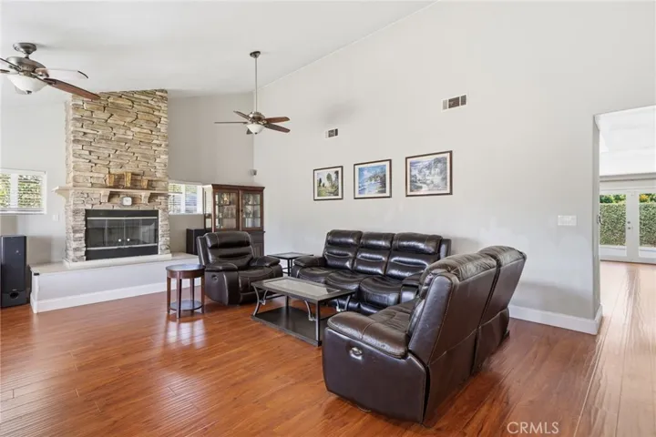 The impressive living room showcases soaring vaulted ceilings and a dramatic floor-to-ceiling stone fireplace
