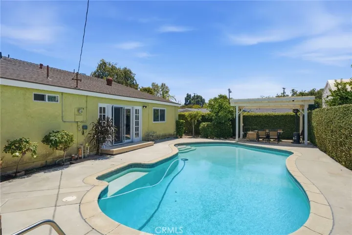 Situated on an oversized 6,700-square-foot interior corner lot, the private backyard is an entertainer's dream featuring a sparkling pool, expansive patio areas, mature landscaping, and multiple spaces for outdoor dining and relaxation.