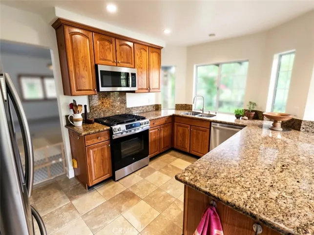 Experience the charm of this updated kitchen featuring a stunning bay window that offers a picturesque view. The open layout seamlessly connects the kitchen to the inviting family room, complete with a cozy fireplace, creating the perfect setting for gatherings and relaxation. This space is truly a must-see for anyone looking to blend functionality with warmth and style. Don't miss out on this exceptional home!