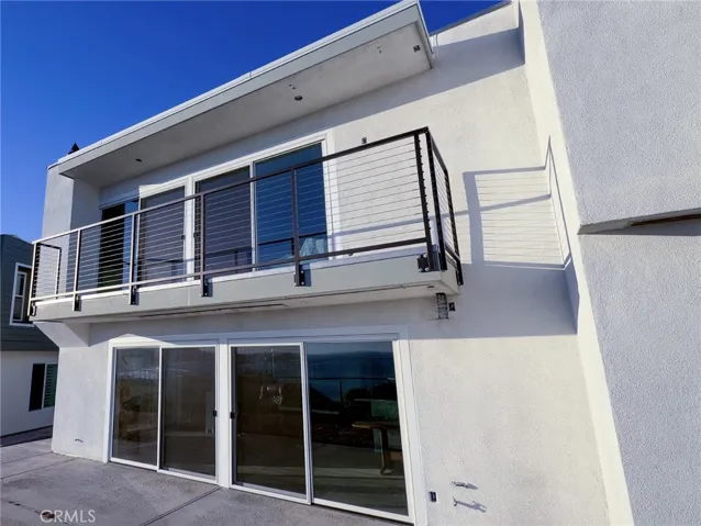 Completed rear exterior renovation featuring modern cable railings designed to enhance ocean-view enjoyment and contemporary coastal appeal.