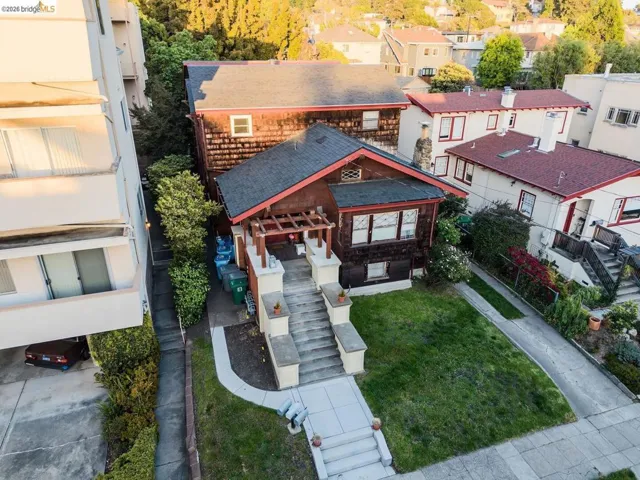Craftsman-style residence featuring a prominent front staircase, pergola-covered entry, and a manicured lawn