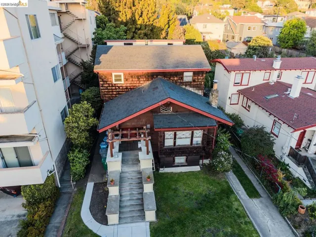 Craftsman-style residence with a dark-shingled exterior and a red-trimmed roofline