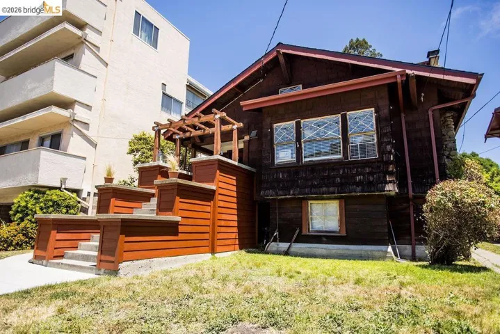 Craftsman-style exterior featuring dark wood siding and a red trim roofline