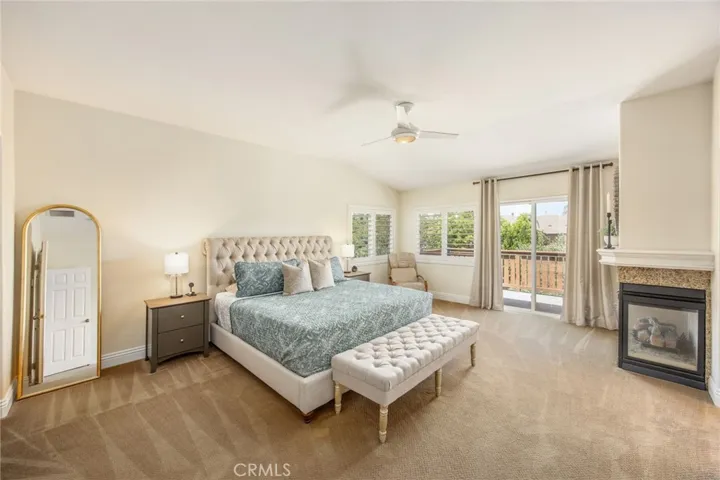 Spacious primary suite with a fireplace, sitting area, and private balcony access