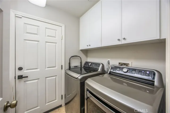 Dedicated laundry room with overhead cabinetry for added storage and organization