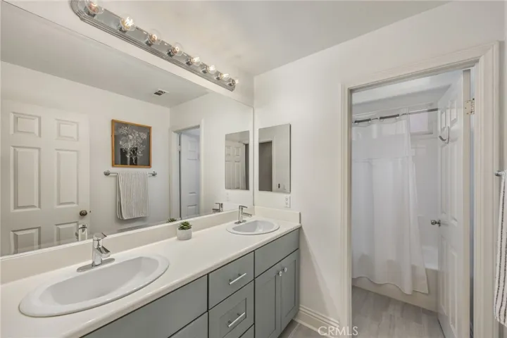Full bathroom with dual sinks and a tub/shower combination